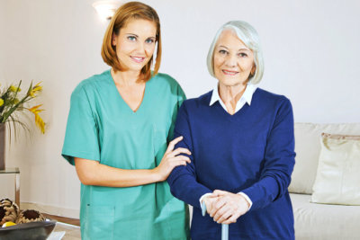 young caregiver and old woman smiling