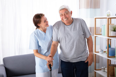 young caregiver and old man smiling