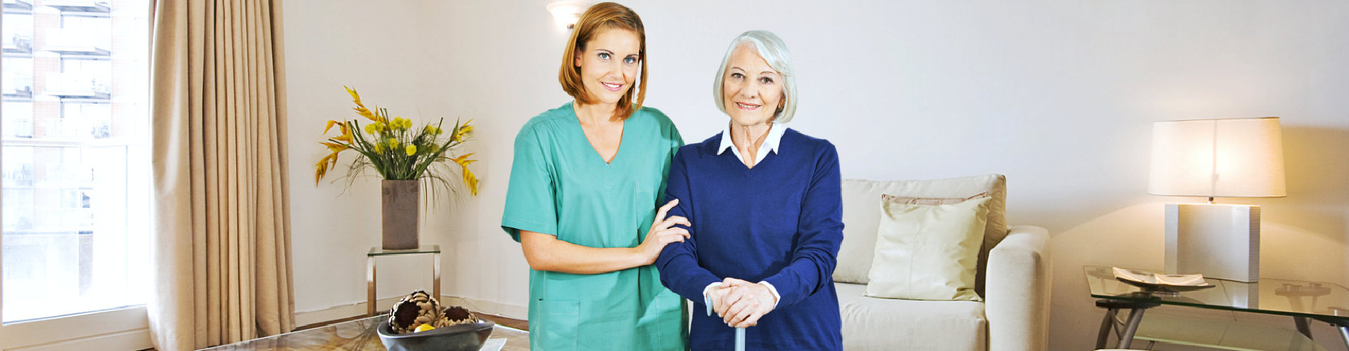 young caregiver and old woman smiling