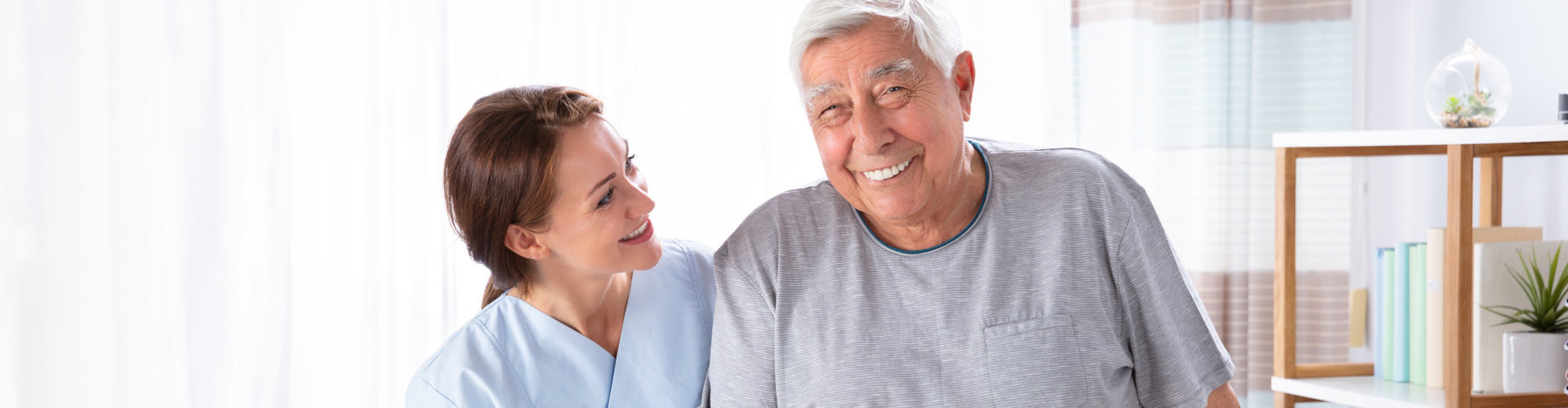 young caregiver and old man smiling